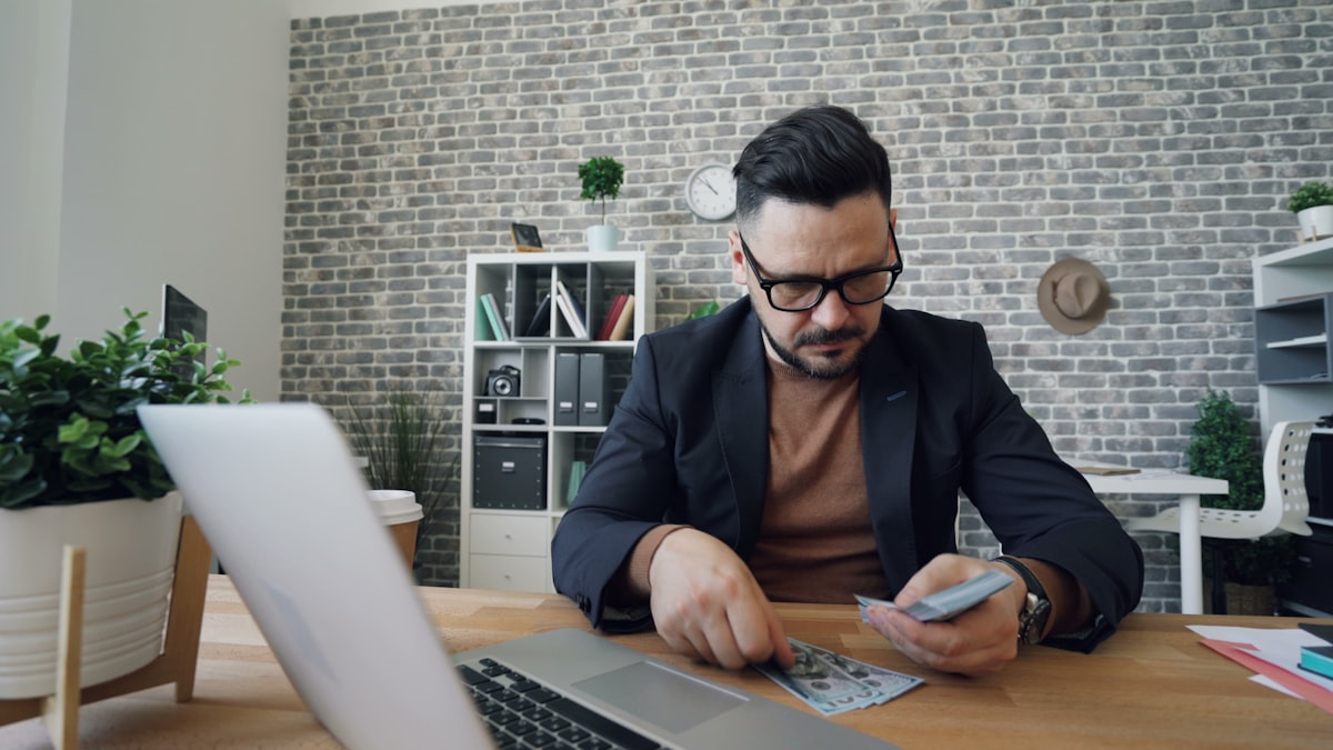 Pria profesional mempelajari investasi di depan laptop